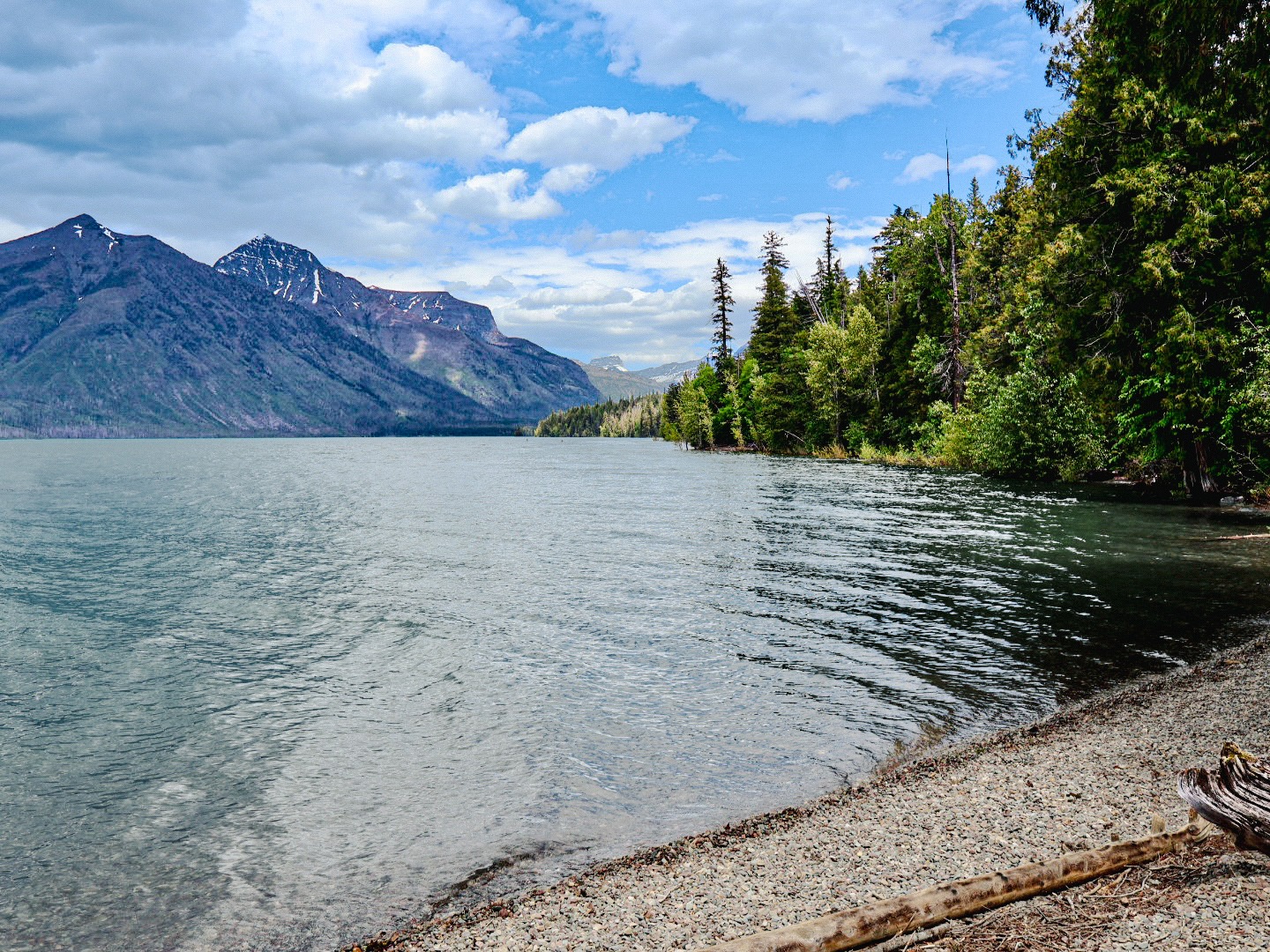 Mountain lake with forested shoreline and blue sky